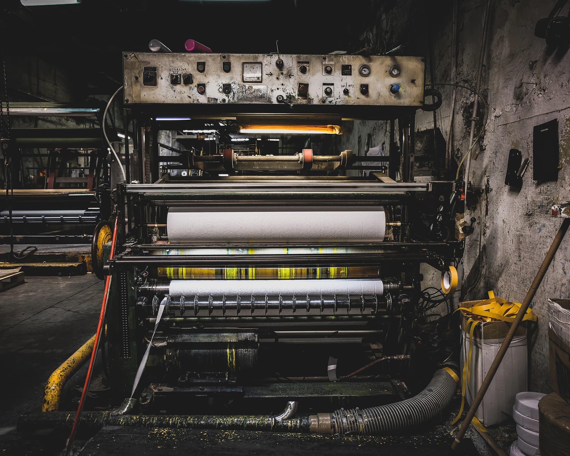 Presse d'imprimerie professionnelle et ses rouleaux de papier, l'atelier où naissent les supports de communication