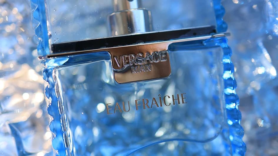 Flacon de parfum Versace Man Eau Fraîche en verre bleu glacé, plaque métallique gravée, en gros plan