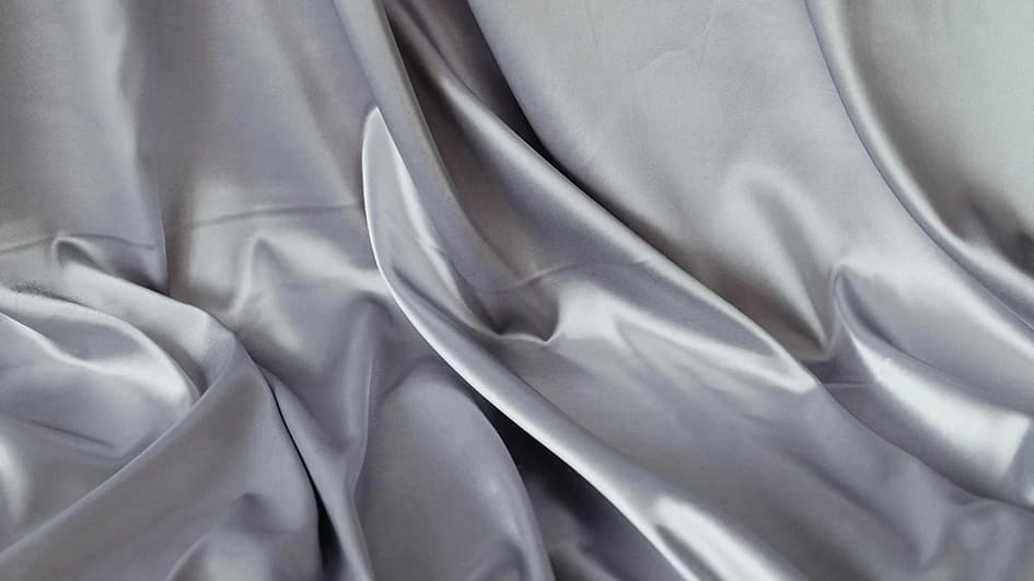 Drapé de satin gris argenté aux plis brillants, évocation de la teinte argent dans l'univers du spa
