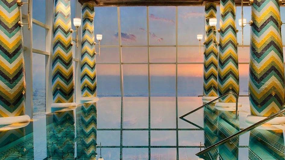 Piscine du Talise Spa au Burj Al Arab Jumeirah à Dubaï, colonnes en mosaïque à chevrons turquoise, jaune et vert