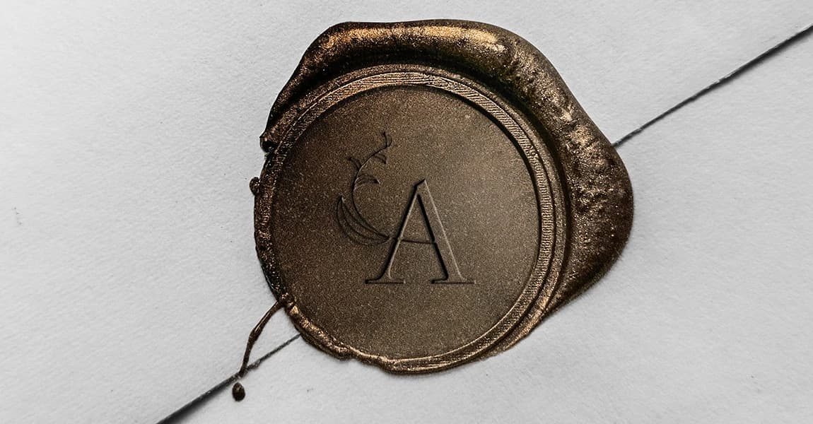 Cachet de cire bronze au monogramme A et fronde de fougère de l'Atelier nantais du paysage sur une enveloppe blanche