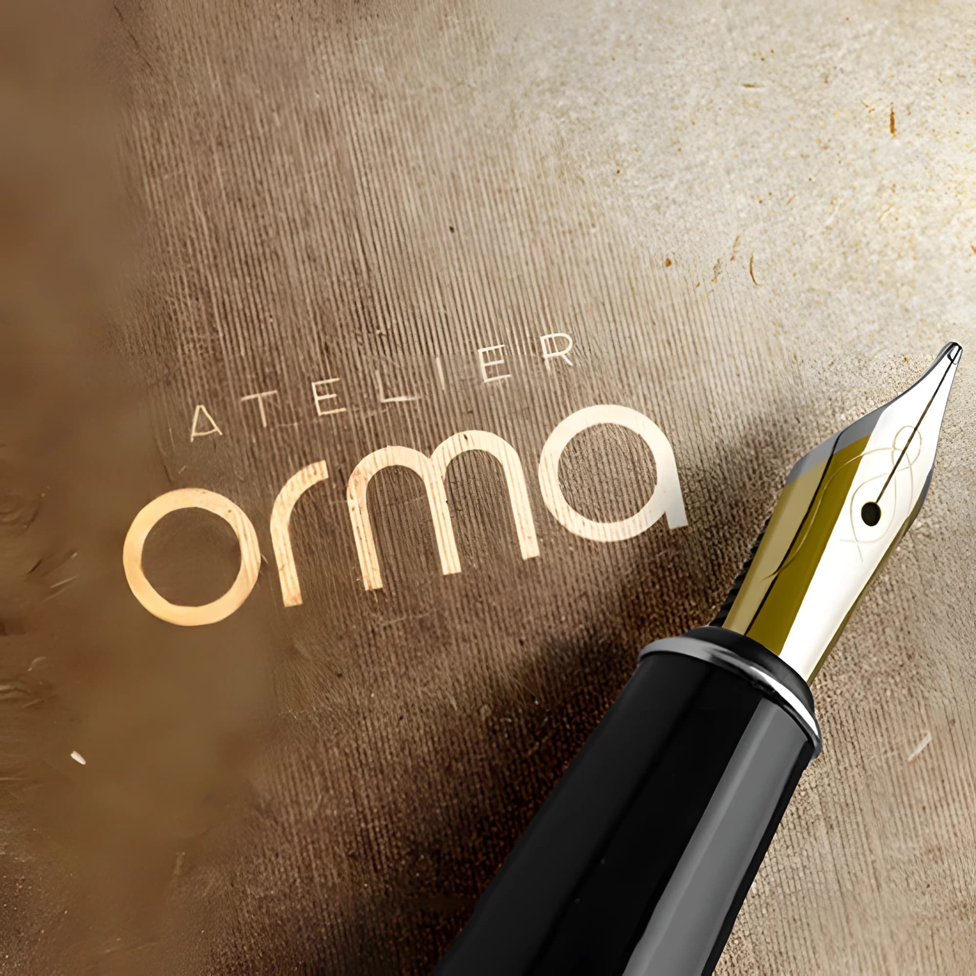 Logo Atelier Orma en lettres sans empattements dorées sur papier kraft, près d'un stylo plume, par le Studio Citron Sorbet