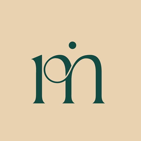 Monogramme lm de L’Art Mada vert sapin sur fond sable, deux lettres reliées par une boucle et surmontées d’un point