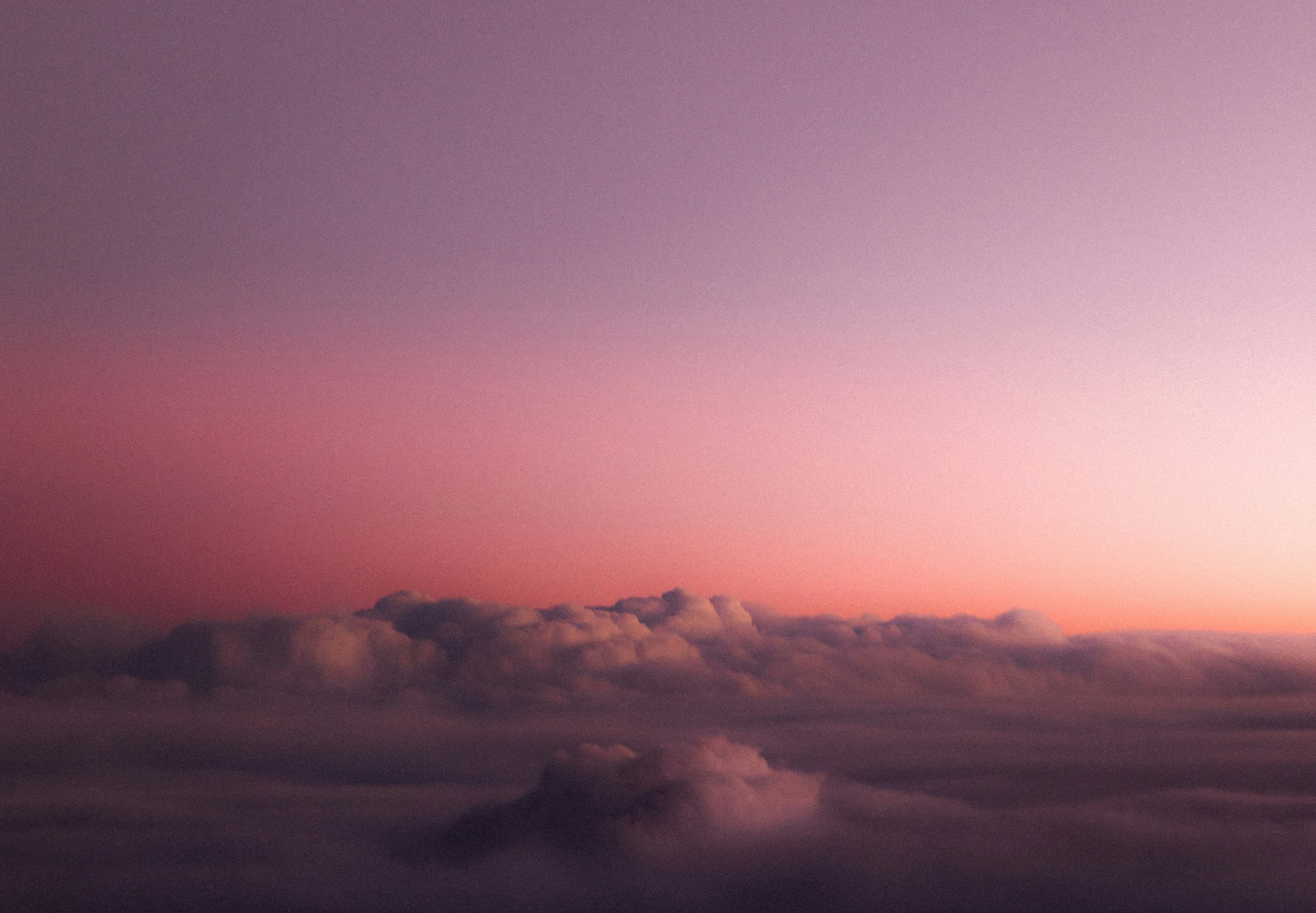 Mer de nuages sous un ciel rose et mauve au crépuscule, photo d’ambiance de l’identité Voix des Sens par le Studio Citron Sorbet, graphiste à Nantes