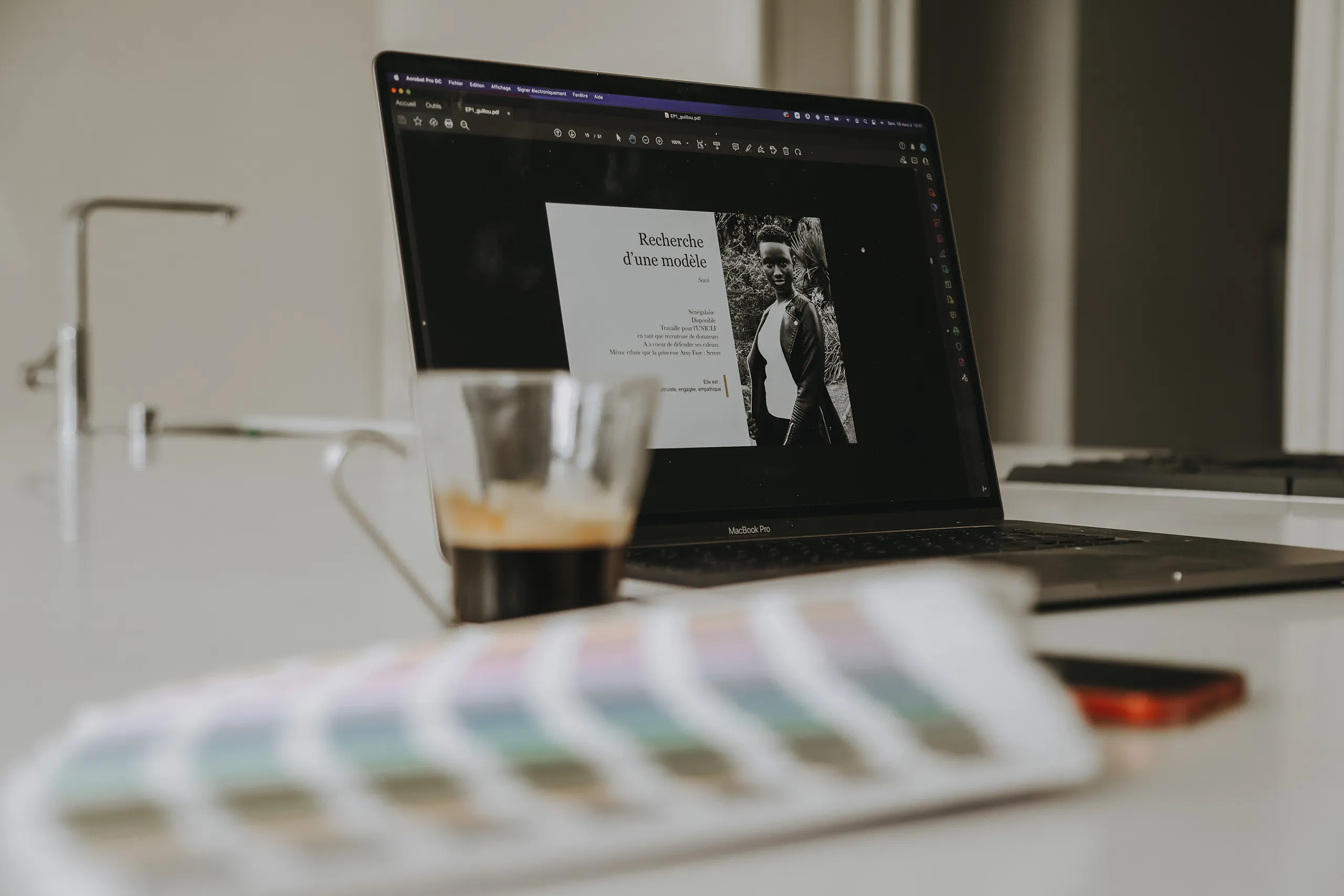 Mise en page « Recherche d'une modèle » ouverte sur un MacBook, avec café et nuancier au premier plan, au Studio Citron Sorbet